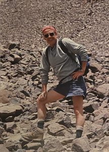A man wearing a backpack standing in a field of rocks