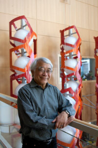 Keith Yamamoto in front of a statue of DNA