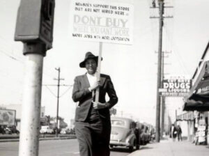 Frances Albrier on sidewalk with picket sign