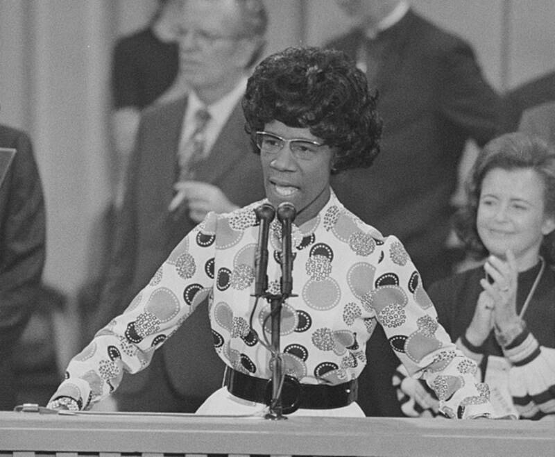 Shirley Chisholm speaking at microphone.