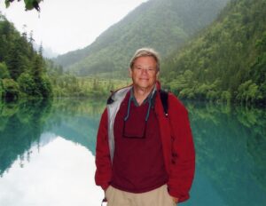 Vince Resh standing before a lake with mountains in the background