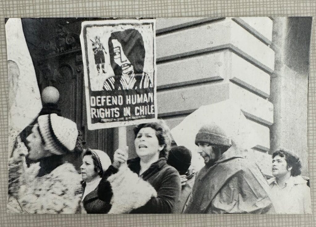 Protest photograph from the Acción Latina archive: woman with sign placard for human rights in Chile