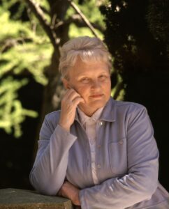 Color photograph of Carolyn Merchant outside with a green tree in the background