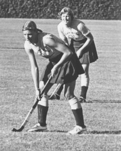 Sheryl Ann Johnson plays field hockey, with another player in the background.