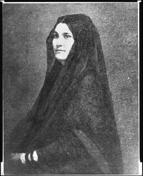 Bust portrait of young woman, identical to the daguerreotype portrait of Ana Maria de la Guerra wearing a lace mantilla, but portrait is a paper print and her hand is visible near bottom corner.