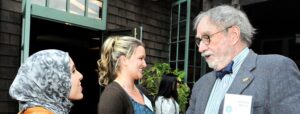 Older man talking with two students who were recipients of a scholarship at an event at UC Berkeley